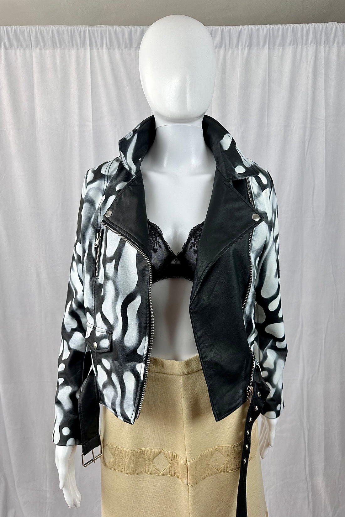 Photo of open painted leather jacket and long skirt on mannequin.